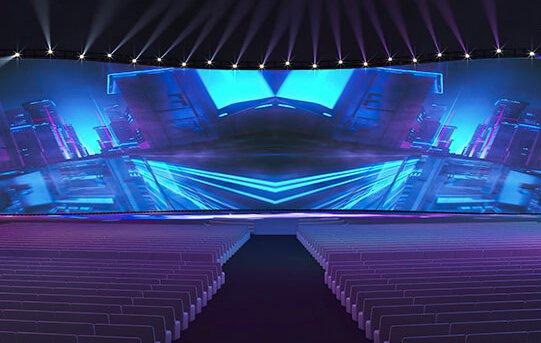 a large stage with a large screen and a large audience