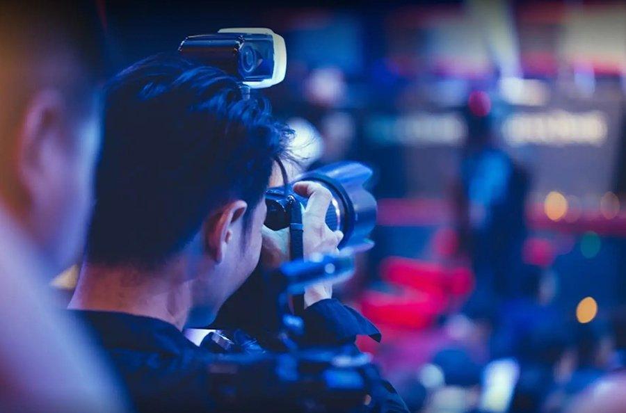 a man with a camera taking a picture of a crowd