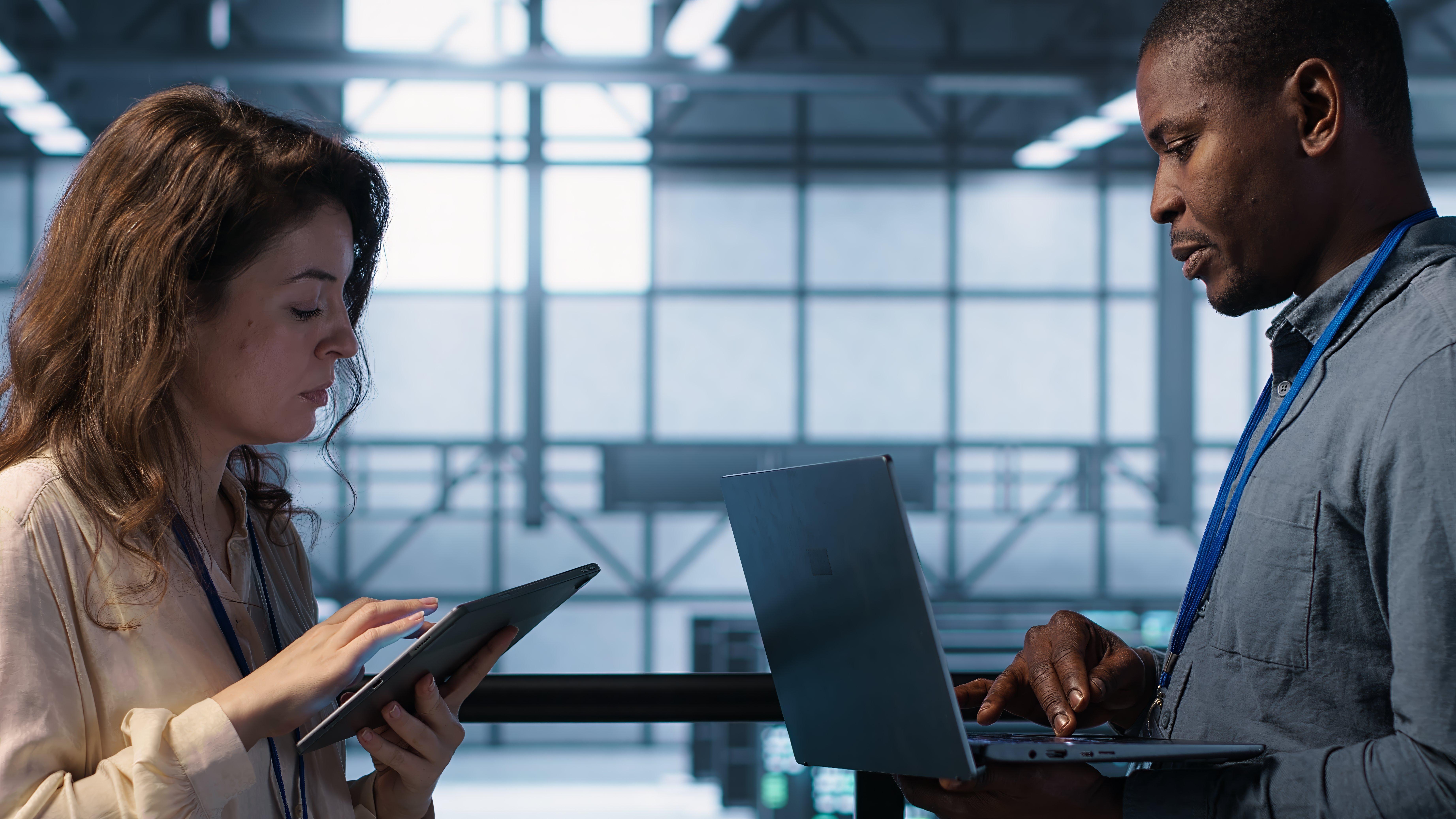 a group of people sitting around a table with laptops and a projector