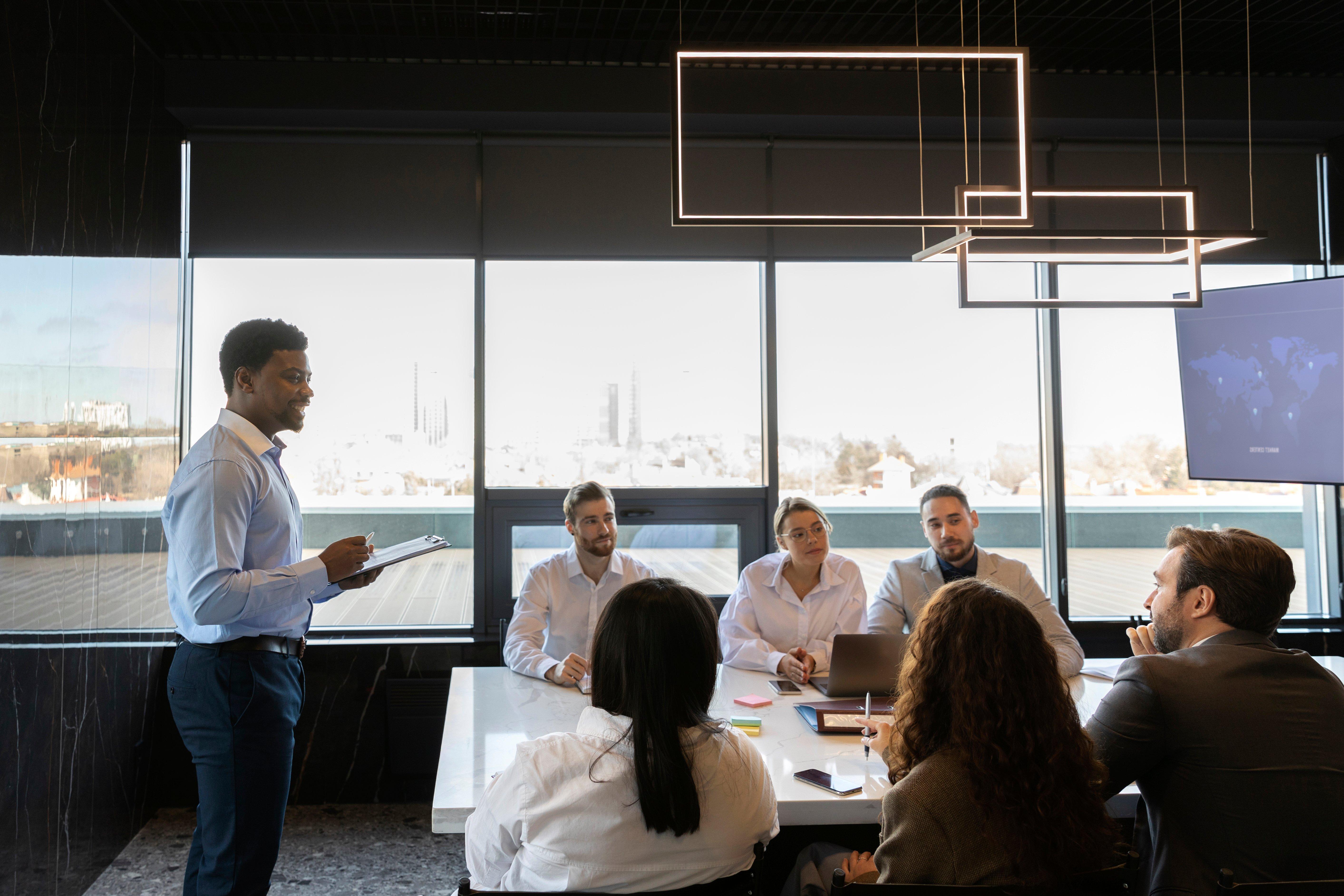 a group of people sitting around a table in a conference room