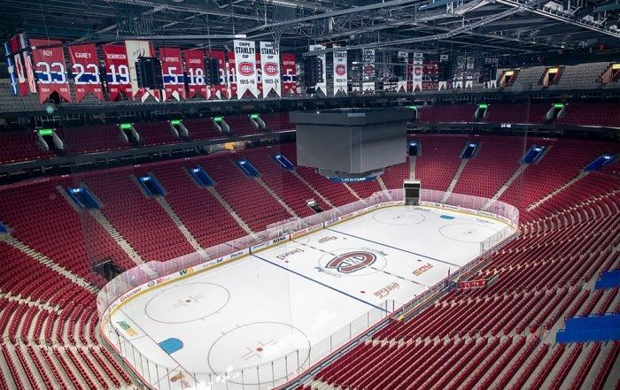 une patinoire de hockey avec des sièges rouges et un tableau d’affichage