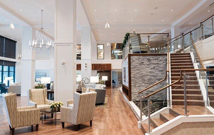 a lobby with a staircase and a large table with chairs