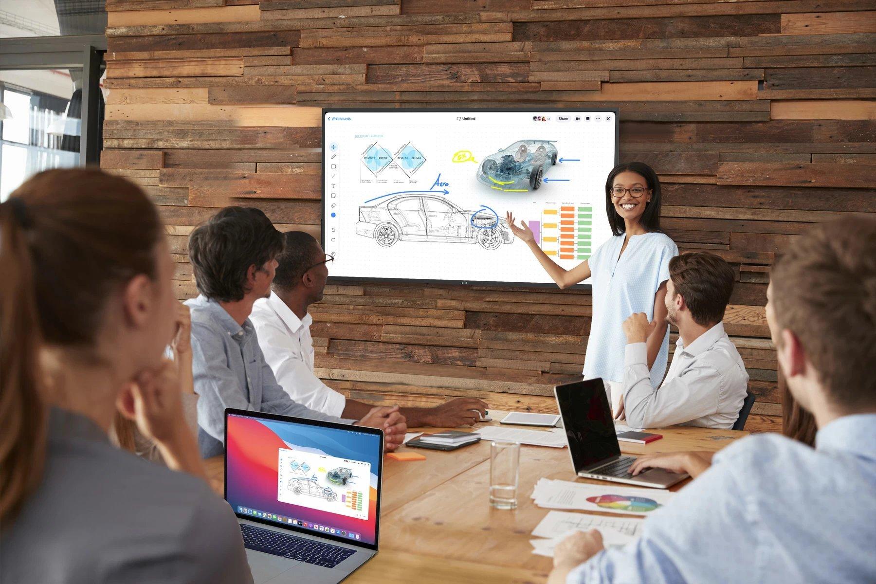 a group in a collaboration space looking at a digital display