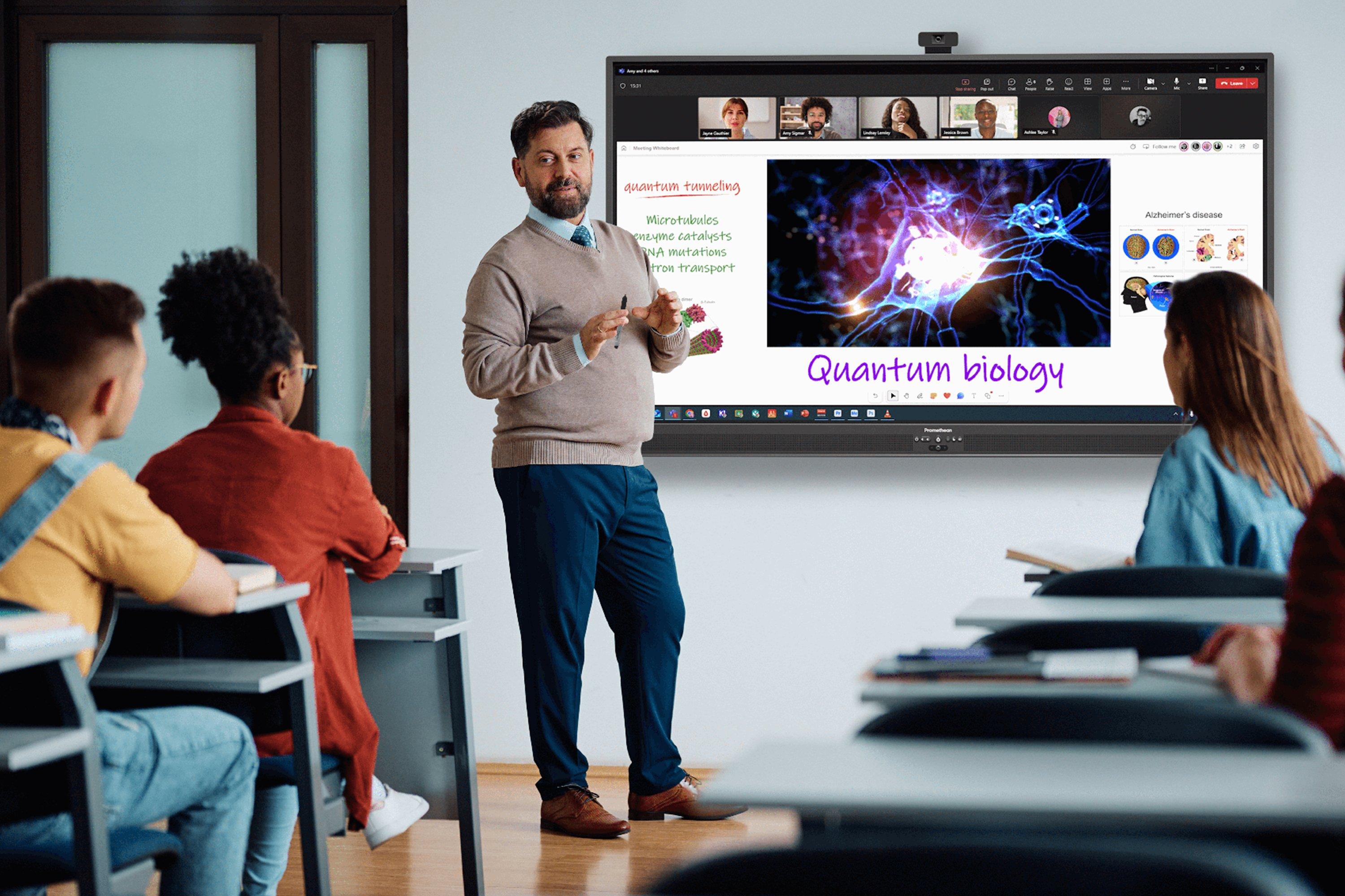 a man standing in front of a large screen in a classroom