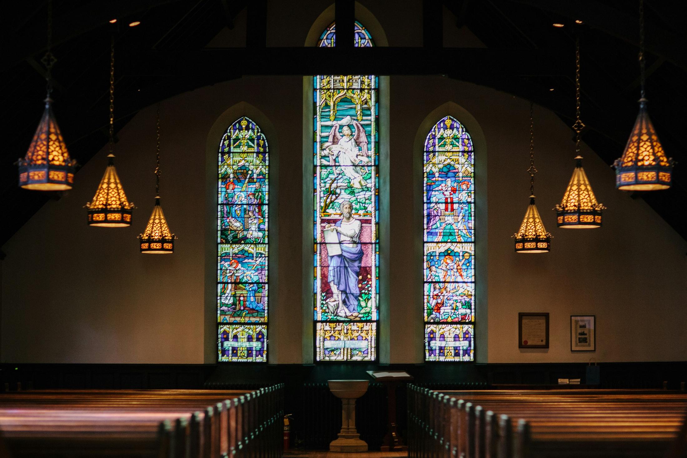 a church pews with stained glass windows and a stained glass window