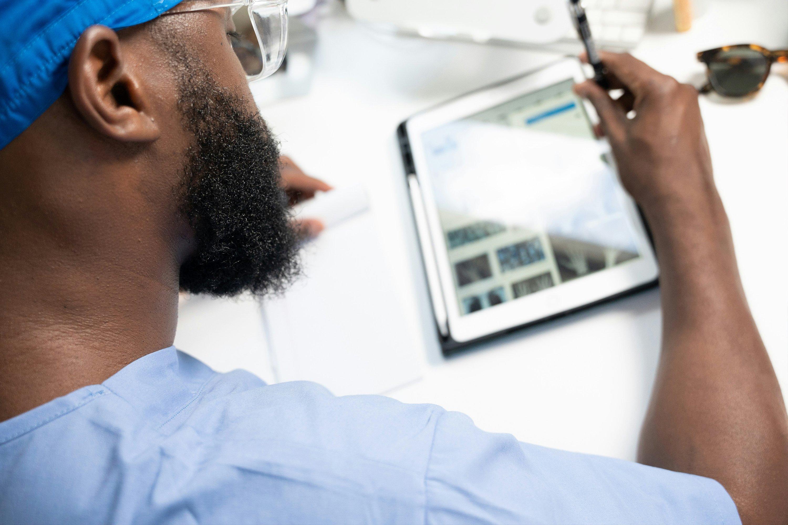 two men sitting at a table with a laptop and a video conference call