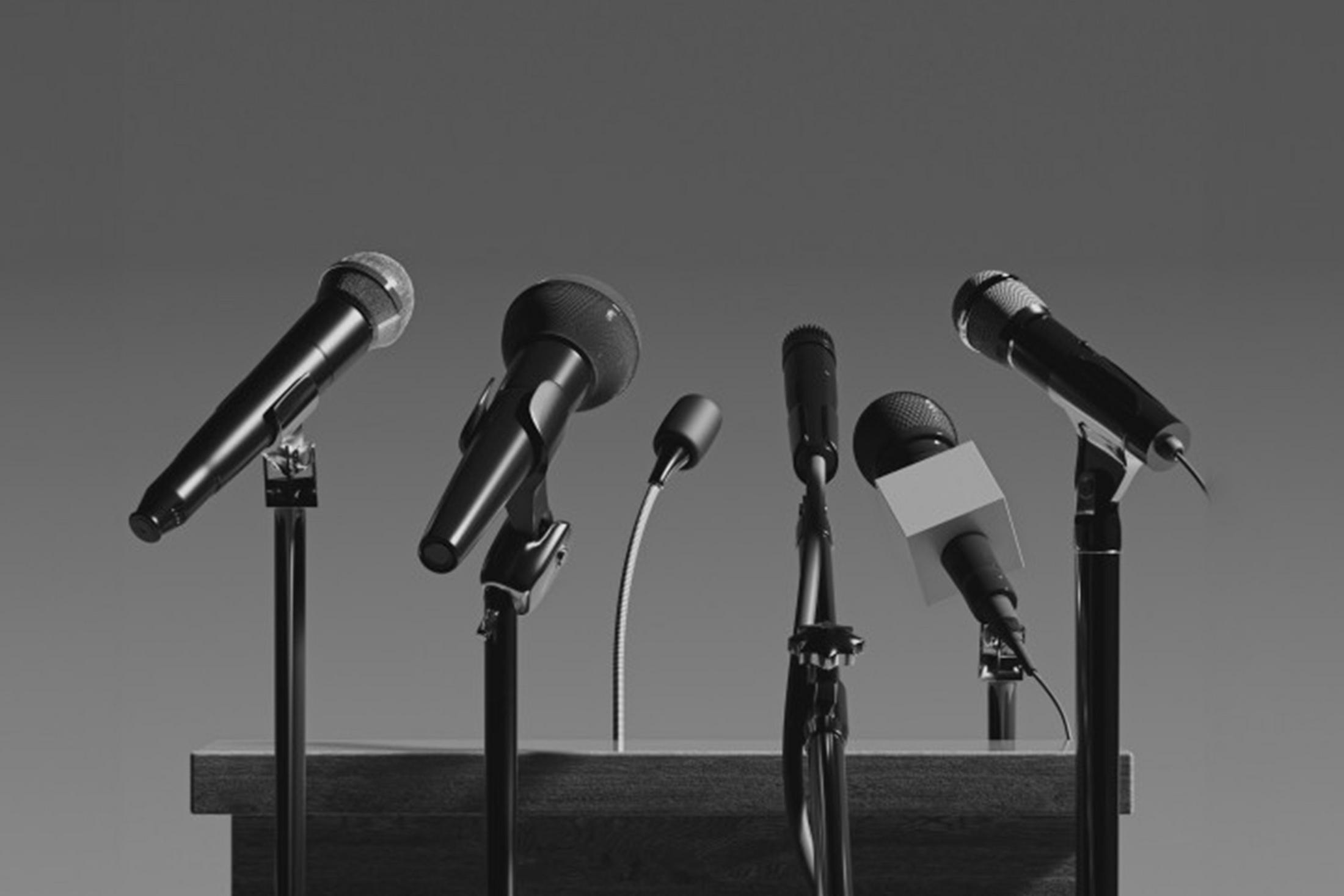 a group of microphones are lined up on a podium