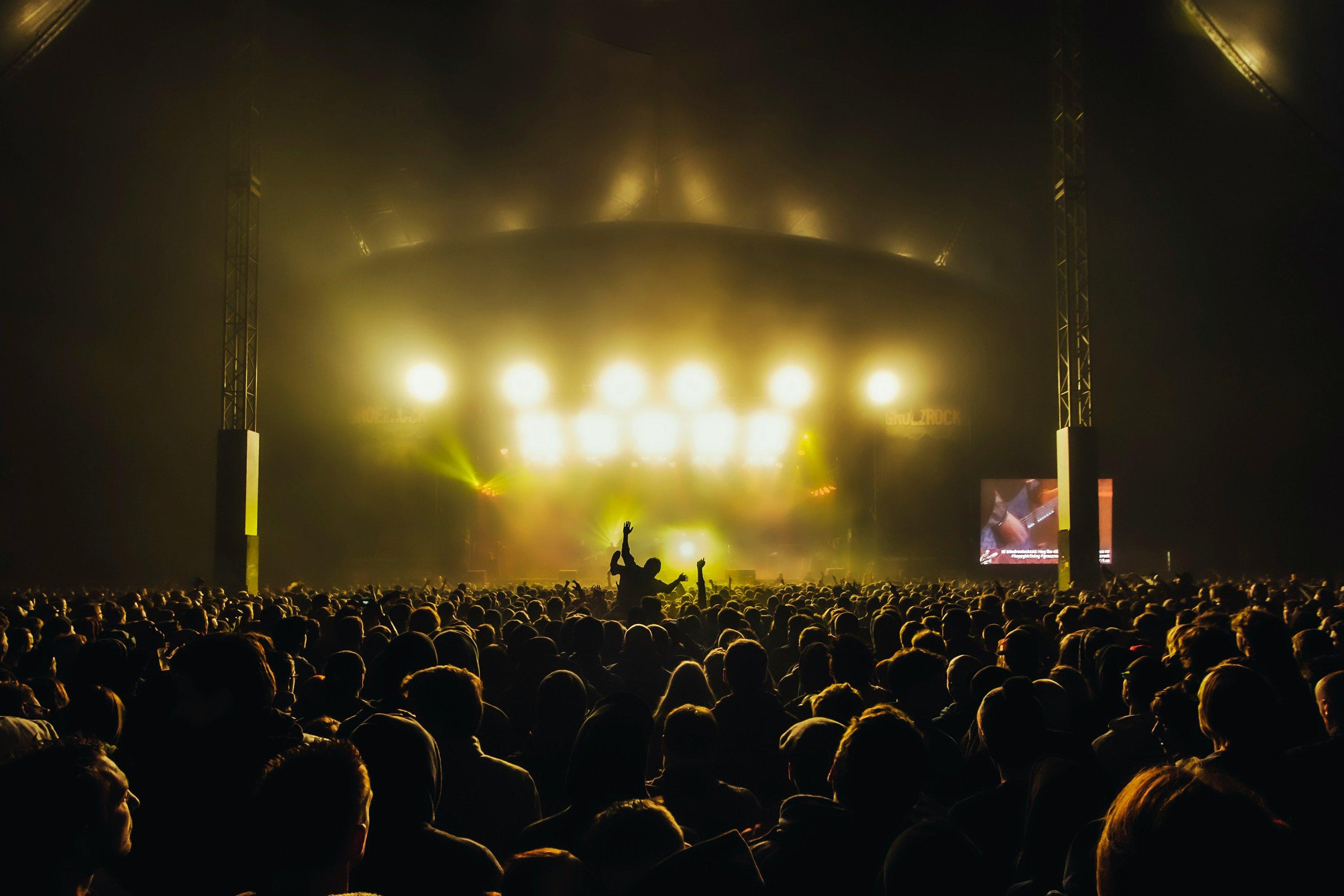 a crowd of people at a concert with bright lights