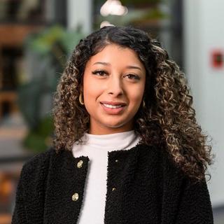 a woman with curly hair standing in front of a building