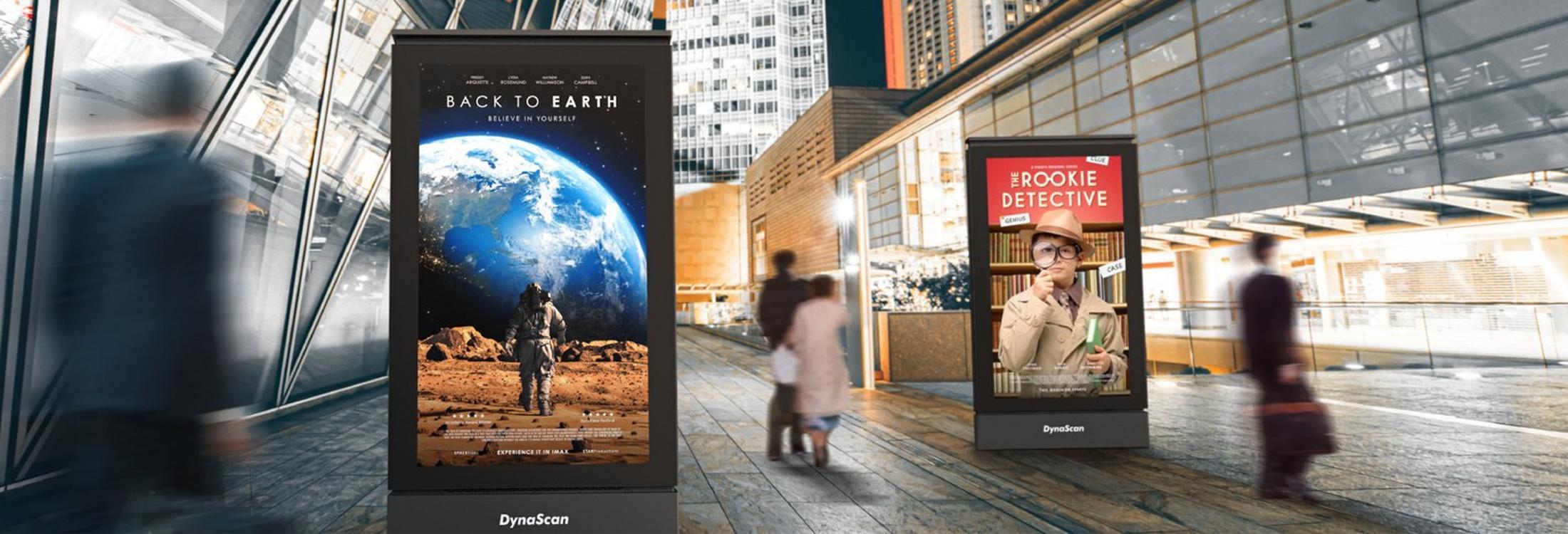 a group of people walking down a street with a billboard in the background
