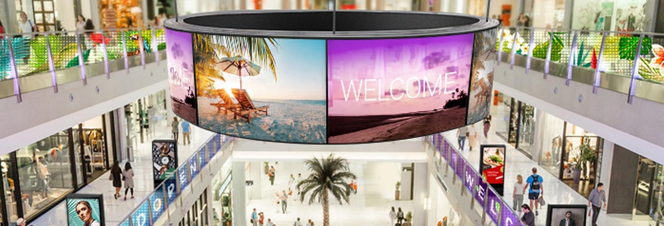 a large circular display in a shopping mall with people walking around