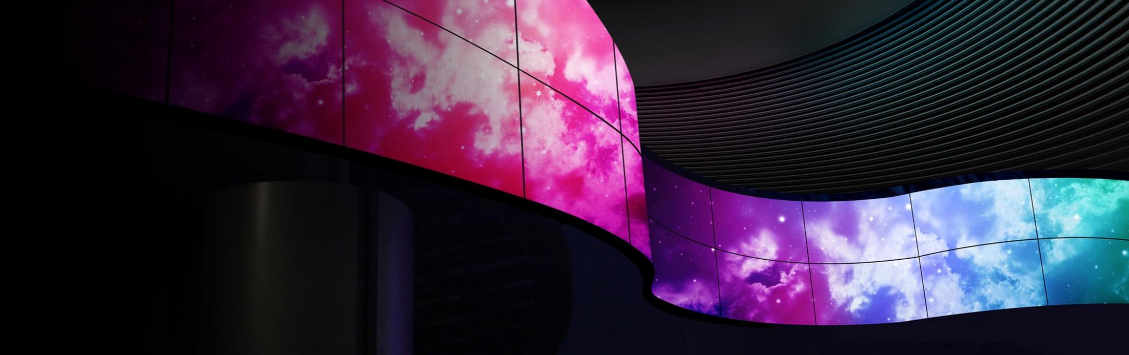 a curved wall with colorful lights on it in a dark room