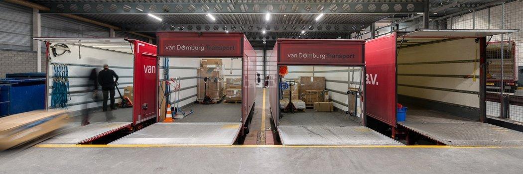 a warehouse with a man pushing a cart through the doors
