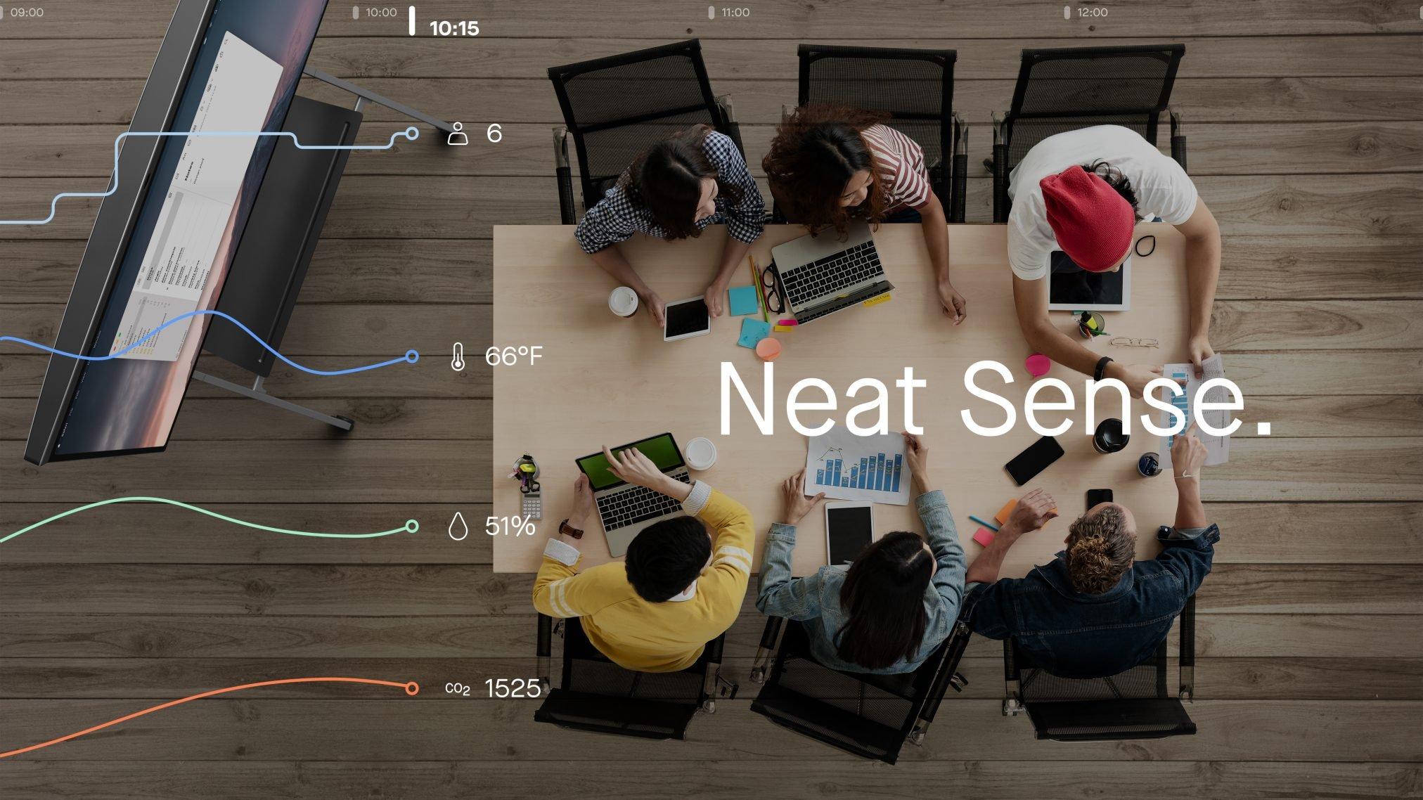 a group of people sitting around a table with laptops