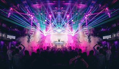 a concert with a large crowd and colorful lights