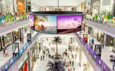 a large indoor mall with people walking around and shopping