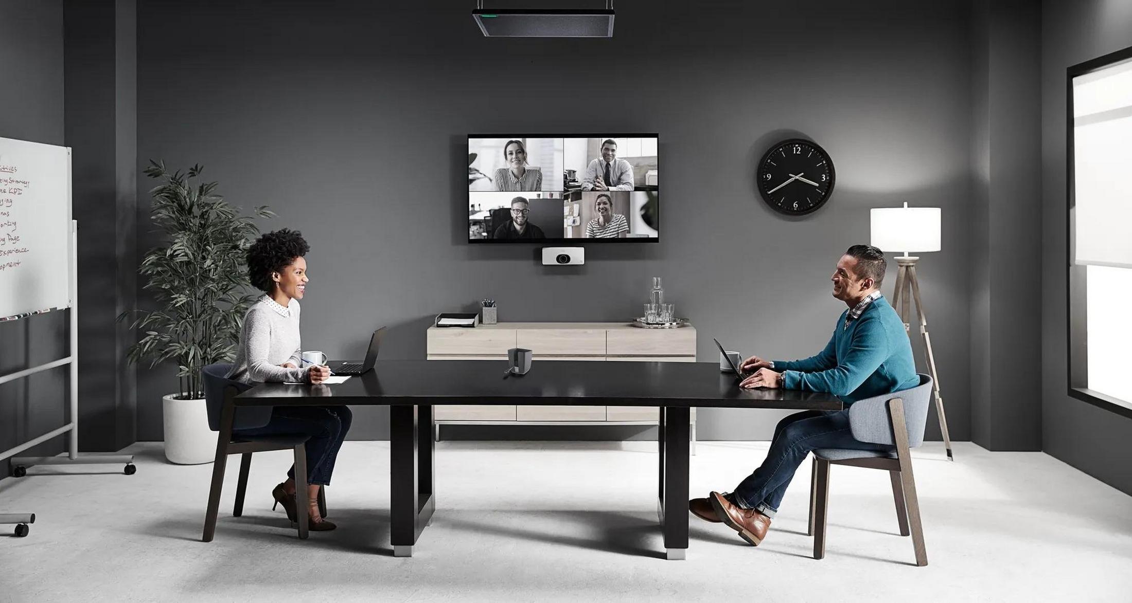 two people sitting at a table in a conference room