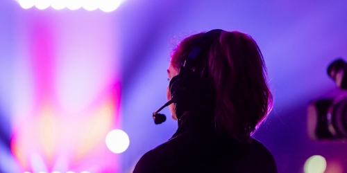 a woman wearing headphones and a headset is looking at a stage a woman wearing headphones and a headset is looking at a stage