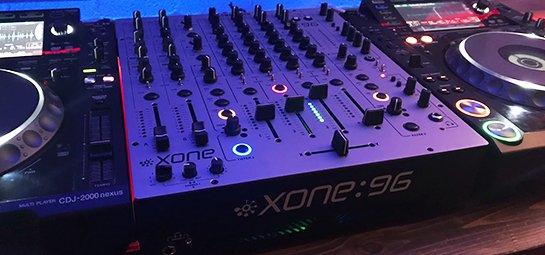 a dj mixer sitting on top of a table with a blue background
