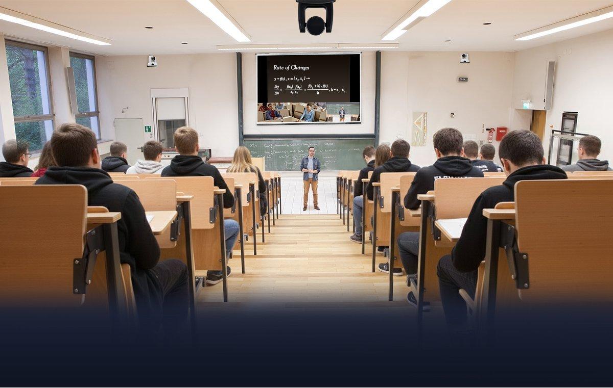 a classroom with a projector and a man standing in front of the class