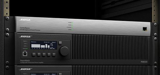 a rack of several audio equipment in a room with a door