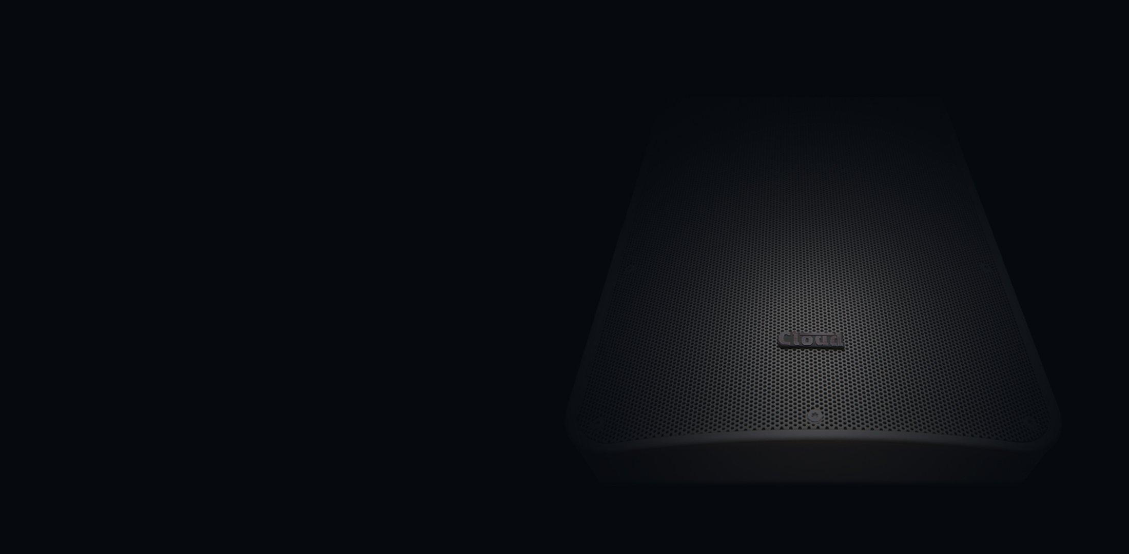 a black speaker with a light shining on it in the dark