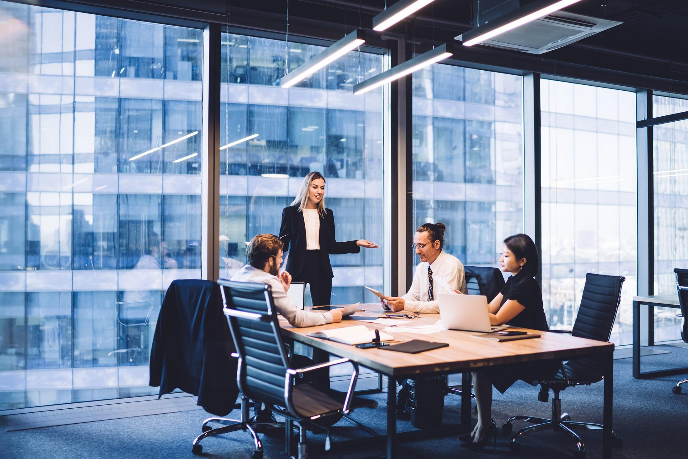 a group of people sitting at a table in an office