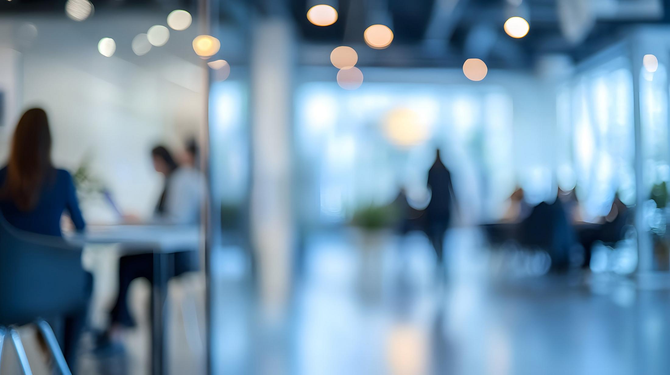 Une photo floue de personnes assises autour d’une table dans une pièce