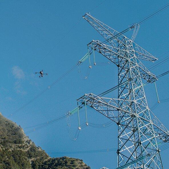 a large power tower with a helicopter flying above it