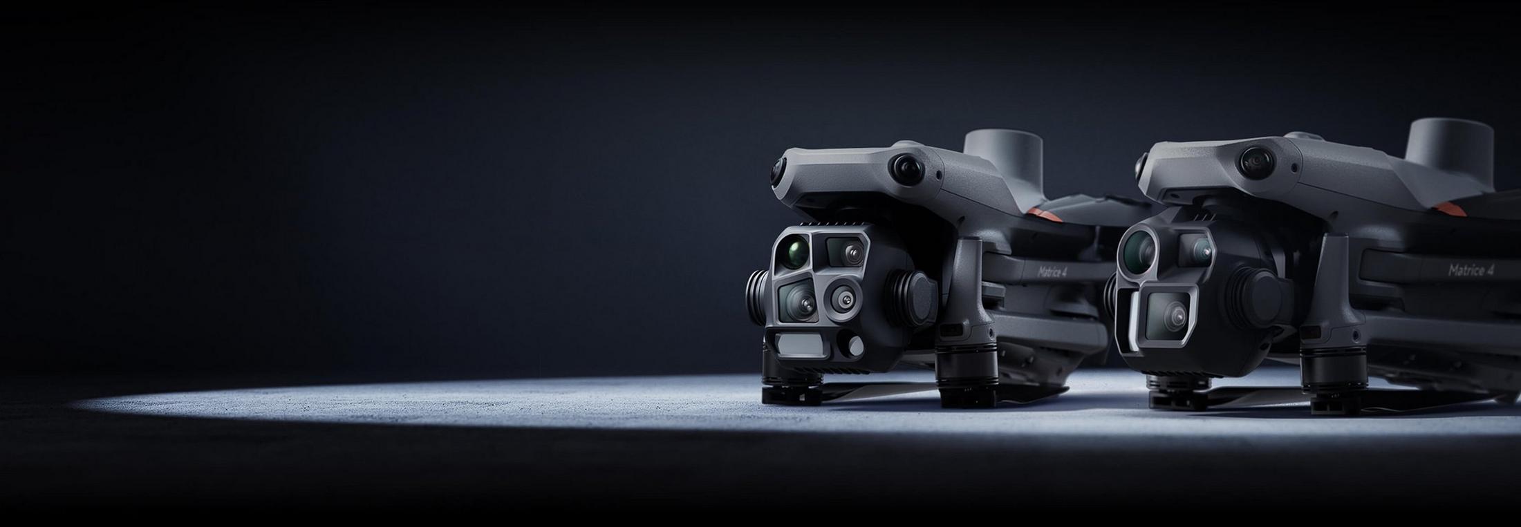 two small cameras are sitting on a table in a dark room