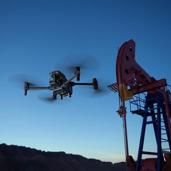 a drone flying over a large oil pump in the desert