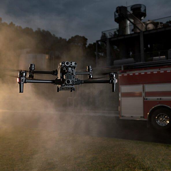 a fire truck and a drone flying in the air in front of a building