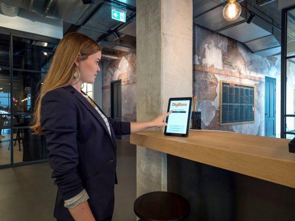 a woman standing at a bar with a tablet computer