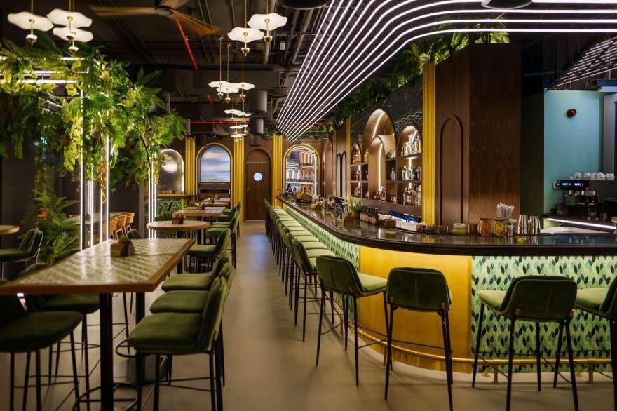 a bar with green chairs and a green ceiling
