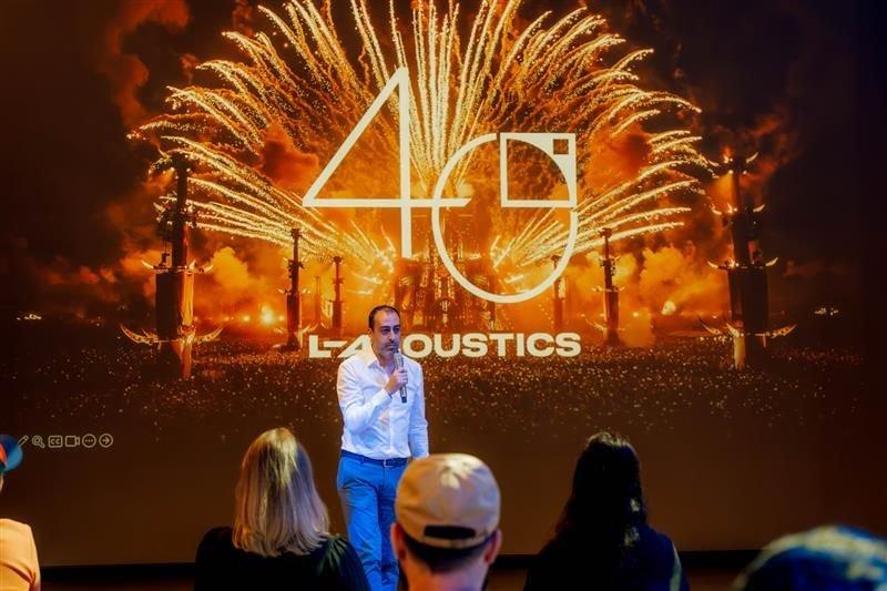 a man is speaking to a crowd at a presentation