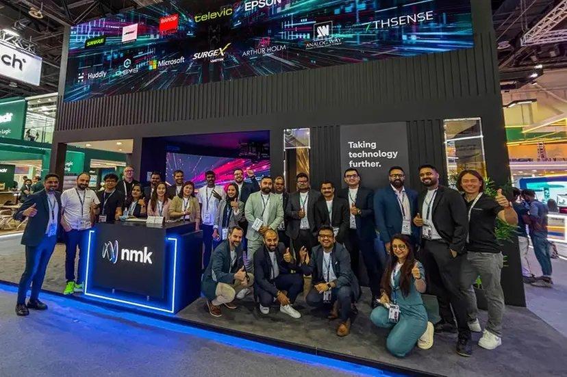 a group of people standing in front of a booth at a trade show