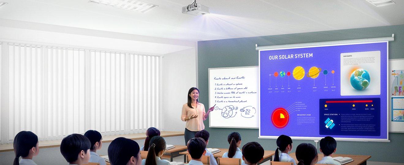 a group of students sitting in a classroom watching a presentation