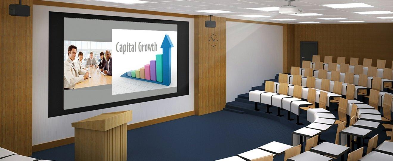 a large room with a projector and chairs for a presentation