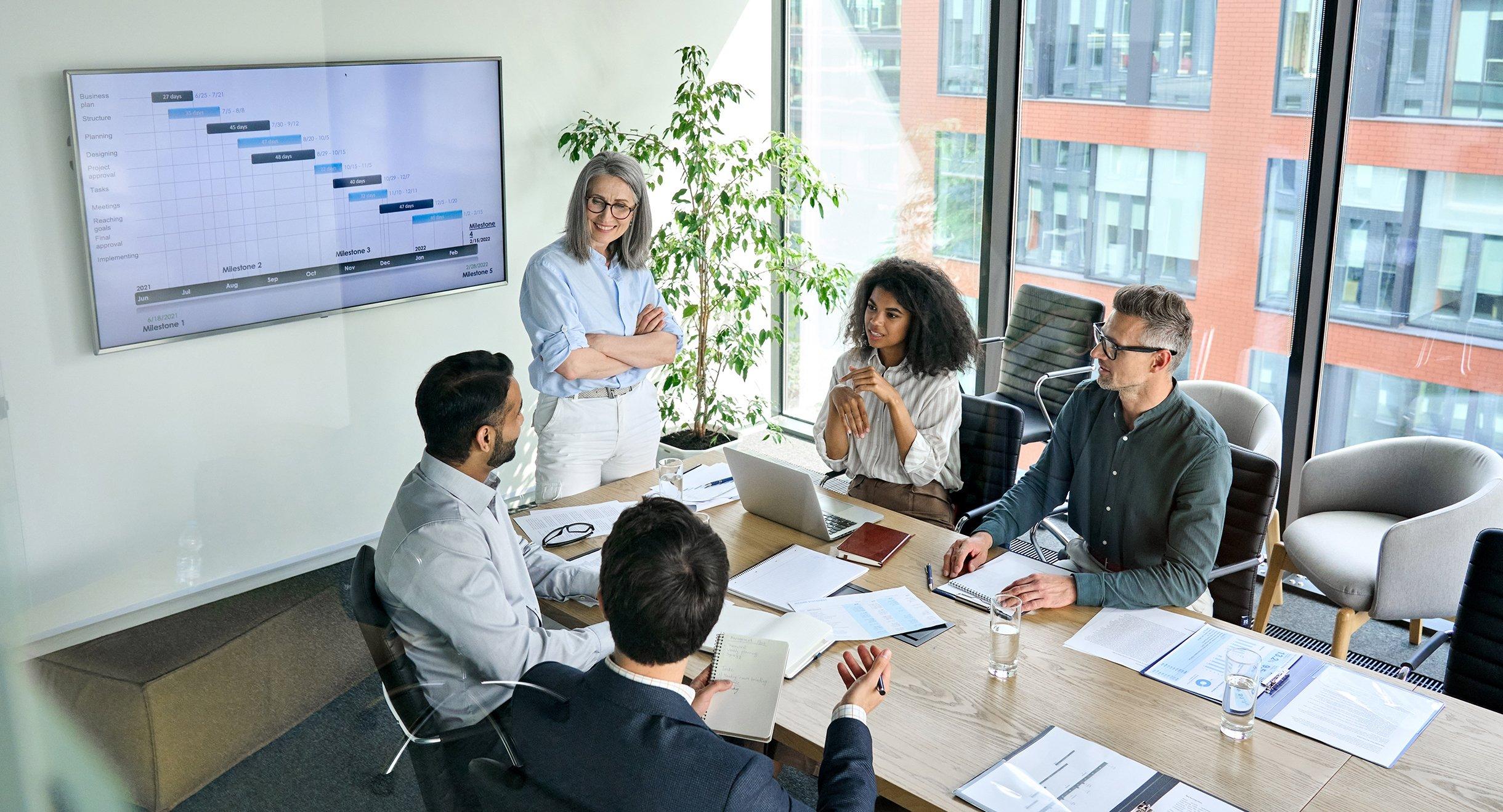 a group of people sitting around a table in a conference room