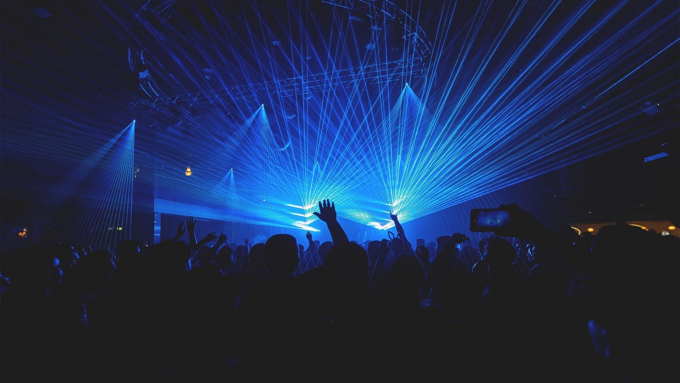 a crowd of people at a concert with blue lights