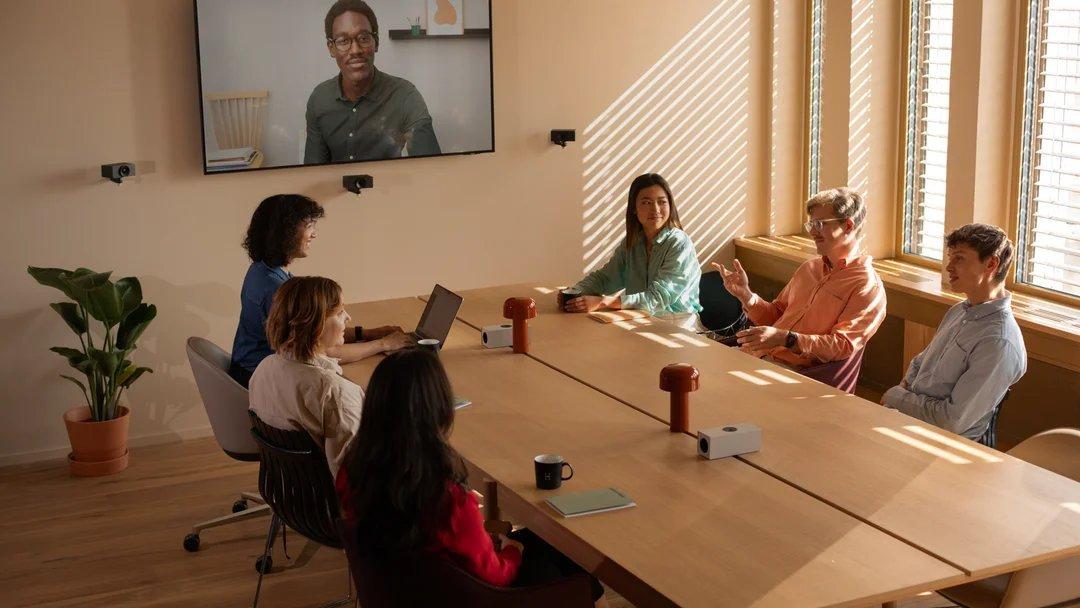 a group of people sitting around a table in a conference room
