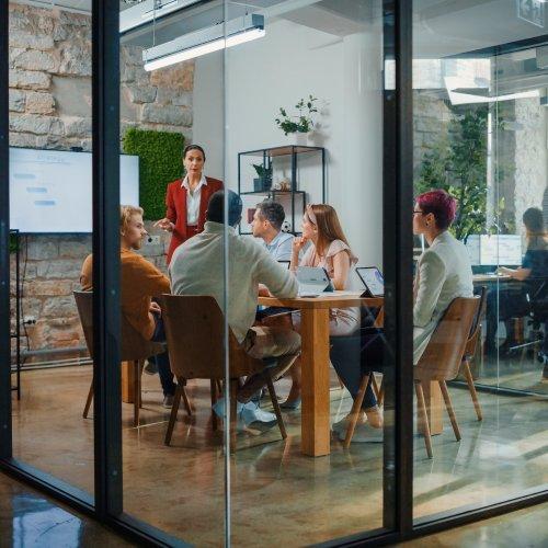 a group of people sitting around a table in a glass room
