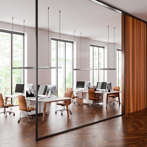 a large open office with wooden floors and a large glass wall