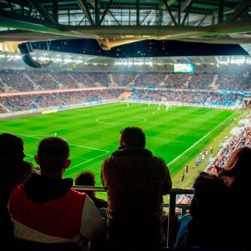 a group of people sitting in a stadium watching a soccer game
