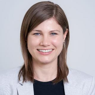 a woman with brown hair and a white shirt