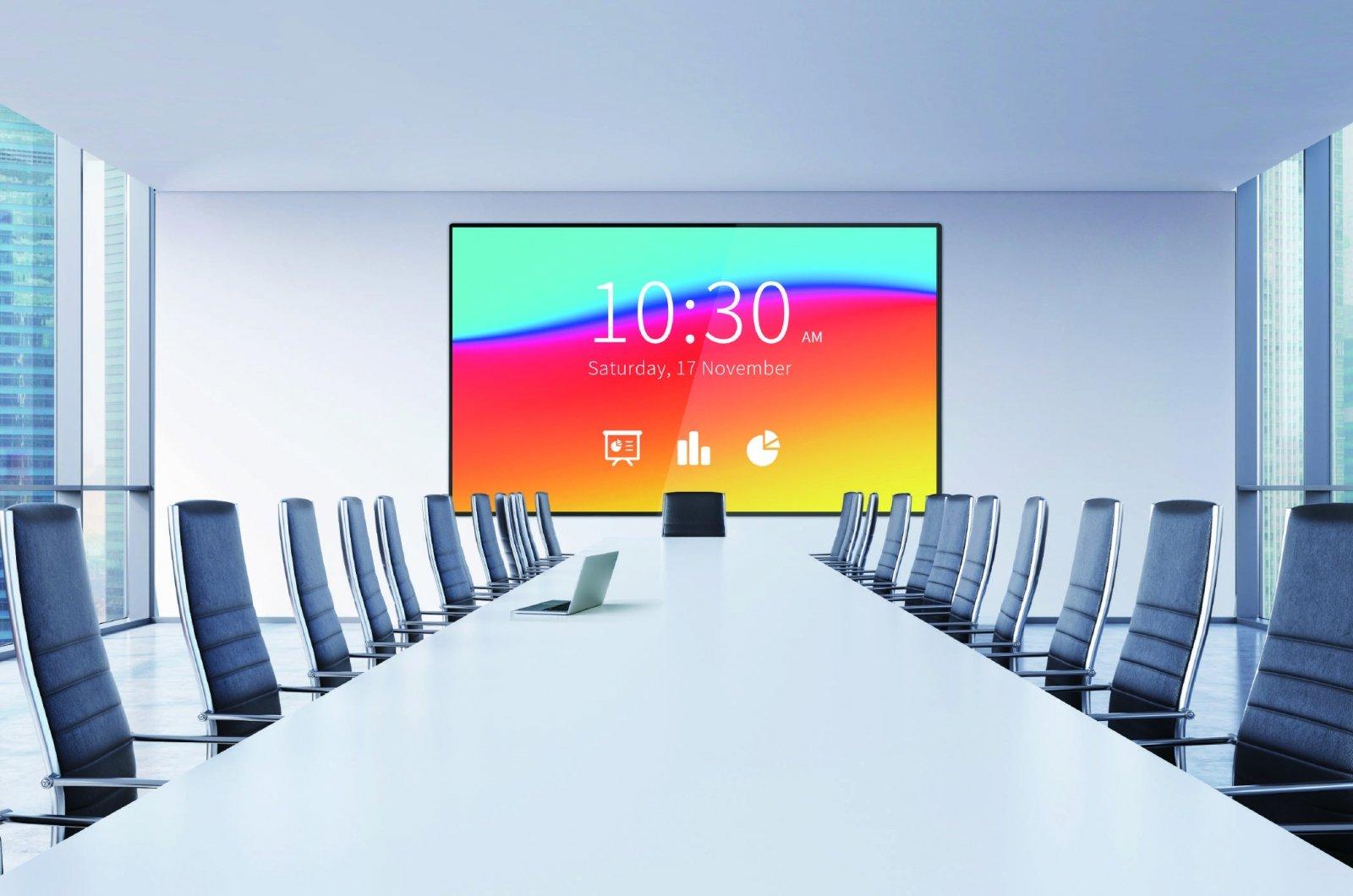 a long table with chairs and a large screen in the middle