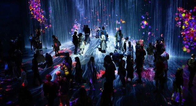 a group of people standing in a dark room with colorful lights