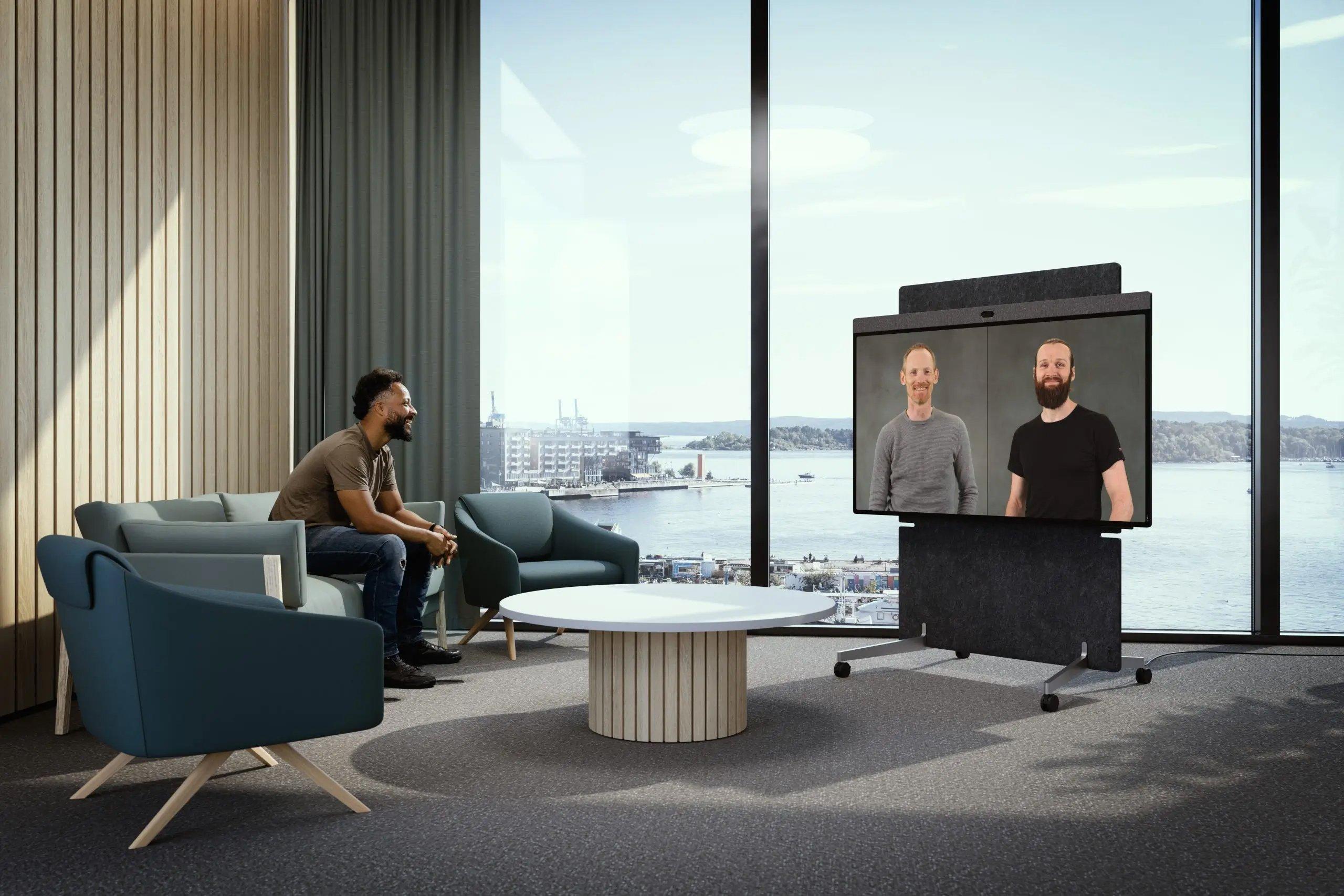 a man sitting in a chair in a room with a tv and a window