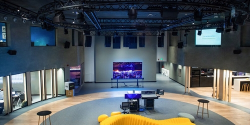 a room with a large yellow chair and a large screen a room with a large yellow chair and a large screen