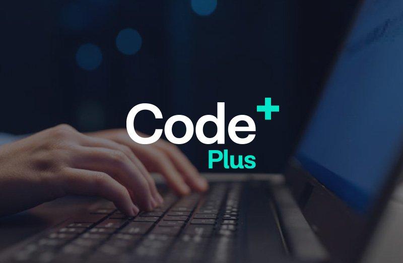 a person typing on a laptop with the word code plus on it